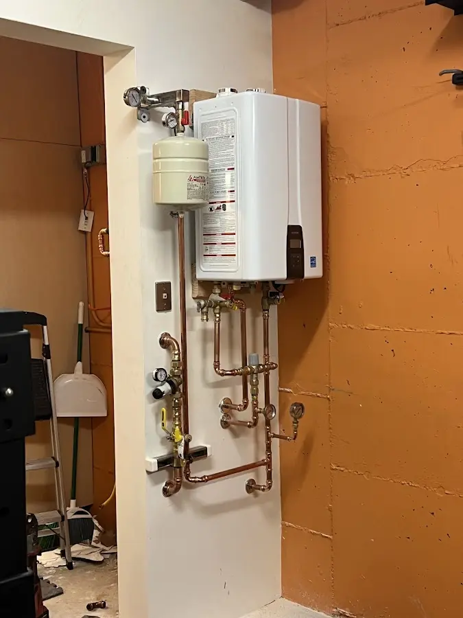 Plumbing technician inspecting water heater connections in Wedgefield